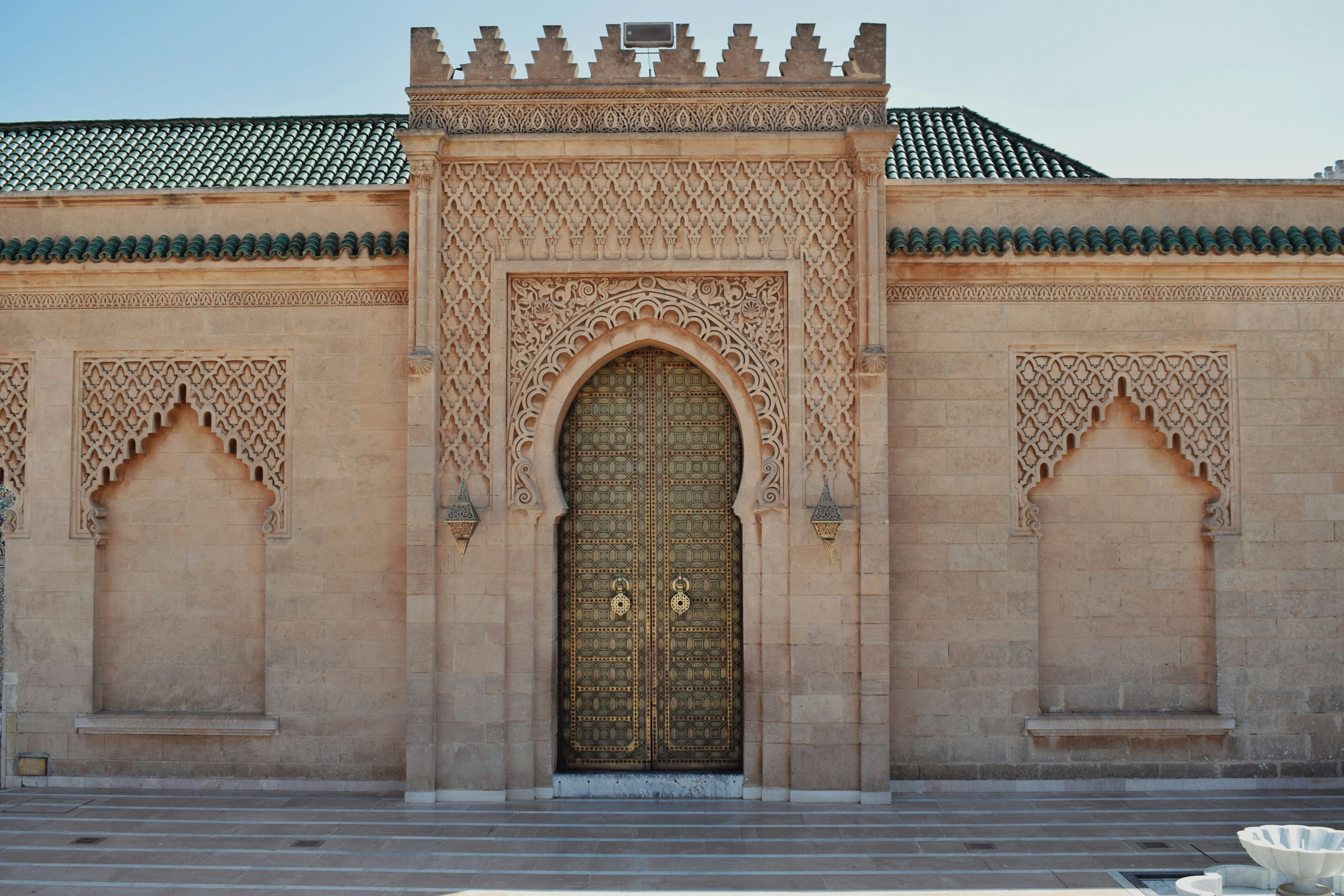 The Royal Palace Gate of Rabat — an architectural masterpiece of Andalusian-Moroccan craftsmanship in gold-and-white carved plaster, zellige tile and cedar